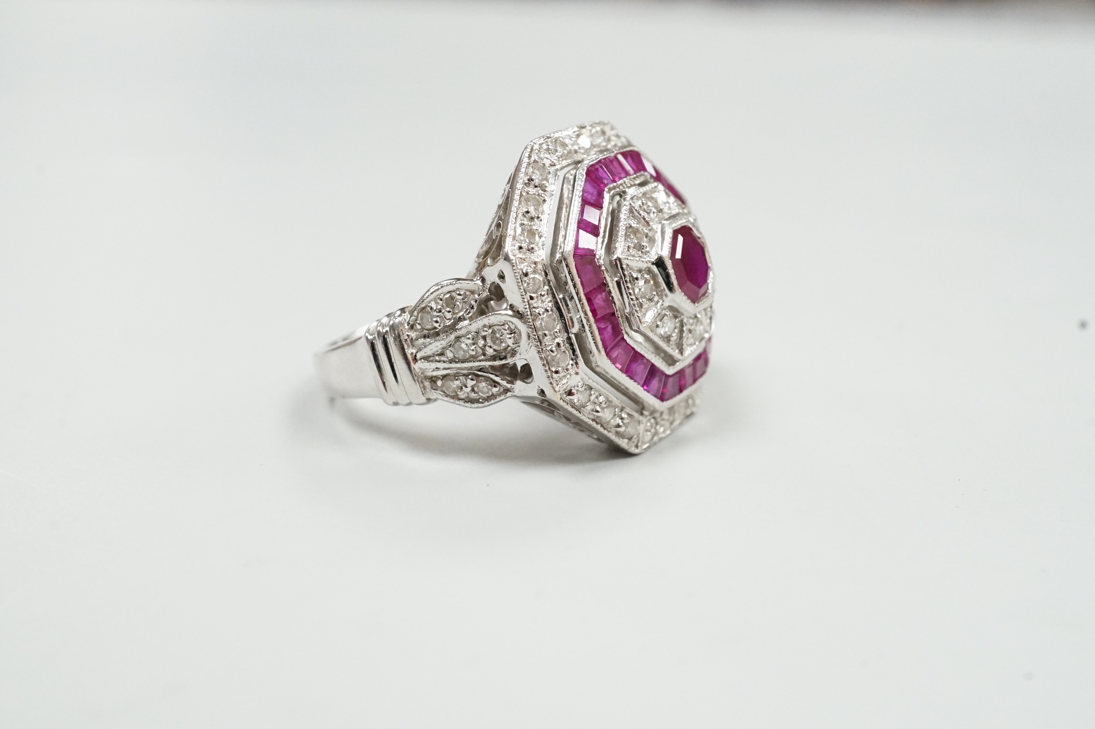 A mid to late 20th century 18ct white gold, ruby and diamond set octagonal cluster target ring, size N/O, gross weight 7.1 grams.